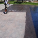 A man washing a floor with a long brush