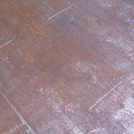 A close up of the floor with scratches and marks.