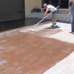 A man is painting the floor of his garage.