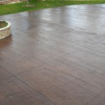 A patio with a cement planter in the middle of it.