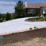 A house with a driveway and landscaping in the background.