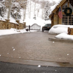 A driveway with snow on the ground and trees