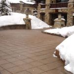 A patio covered in snow near a building.