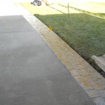 A sidewalk with yellow brick border and grass.