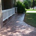 A walkway with brick steps and a bench.