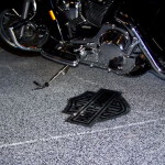 A motorcycle is parked in the garage with its tire on it.