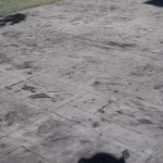 A concrete slab with some black spots on it