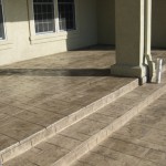 A cement patio with steps leading to the porch.