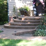 A person walking up steps in front of a house.