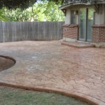 A patio with a brick pattern and a concrete slab.