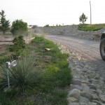 A car driving down the road near some rocks.