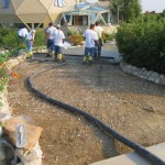 A group of people standing around a driveway.