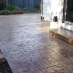 A patio with a cement floor and brick pattern.