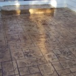 A patio with a brick pattern and a concrete floor.