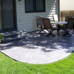 A patio with chairs and table in the middle of it.