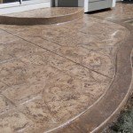 A patio with a curved edge and a stone pattern.