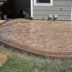 A patio with a concrete slab and grass.