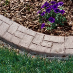 A flower bed with purple flowers and grass.