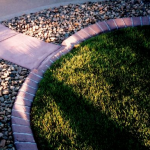 A close up of grass and gravel in the sun.