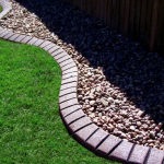 A garden with grass and rocks in the middle of it