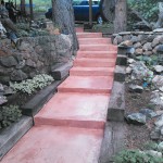 A pink staircase in the middle of a garden.