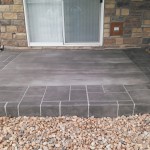 A patio with stone and tile on the ground.