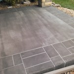 A patio with a stone floor and a cement slab.