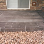 A patio with a stone floor and brick wall.