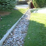 A garden with grass and rocks in the middle of it