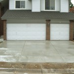 A white two car garage with concrete driveway.