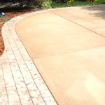 A brick driveway with a walkway and landscaping.