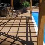 A patio with an umbrella shade over the pool.