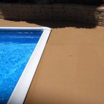 A pool with a brick wall and a blue water