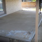 A man standing on the cement floor of his house.