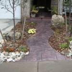 A walkway with a brick pattern and a stone path.