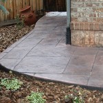 A walkway with a brick pattern and concrete.