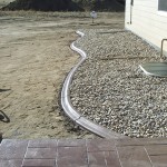 A patio with gravel and brick in the middle of it