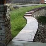 A walkway with steps leading to the side of a house.