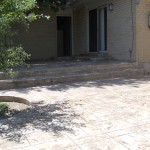 A brick patio with steps leading to the front door.