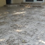 A patio with steps and a large concrete slab.