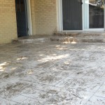 A patio with steps leading to the front door.