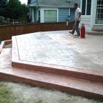 A man is standing on the steps of his home.