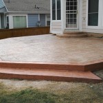 A patio with steps leading to the back deck.