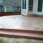 A patio with steps leading to the back yard.