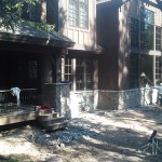 A house with many windows and doors in the back yard.