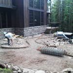 A man working on the ground in front of a house.