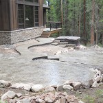 A patio with stone steps and a bench.