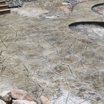 A patio with a stone pattern and rocks.