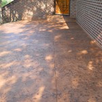 A patio with a brick wall and yellow door.