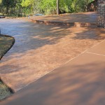 A concrete walkway with steps leading to the driveway.